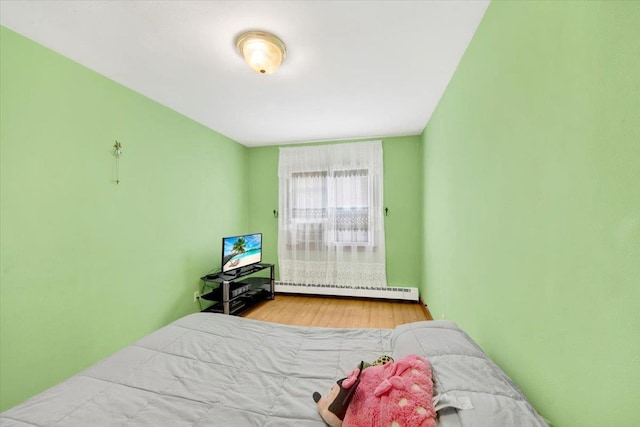 2559 Seymour Ave, Bronx, NY 10469 - bedroom with a baseboard heating unit and wood finished floors