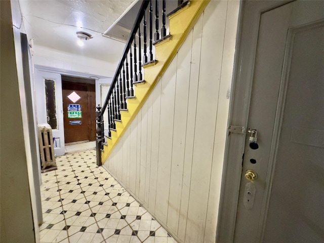 foyer entrance featuring radiator and stairs