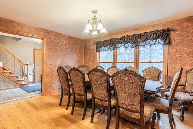 26 Cowboy Trl, Saugerties, NY 12477 - dining space featuring light wood finished floors, wallpapered walls, an inviting chandelier, and stairs