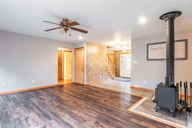26 Cowboy Trl, Saugerties, NY 12477 - unfurnished living room with baseboards, stairway, a ceiling fan, a wood stove, and wood finished floors