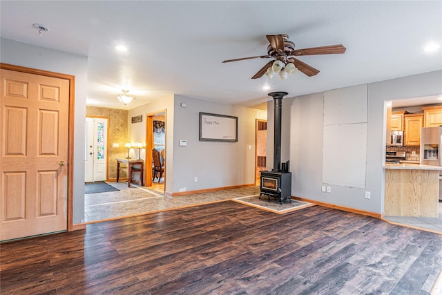 26 Cowboy Trl, Saugerties, NY 12477 - unfurnished living room with a wood stove, baseboards, a ceiling fan, and wood finished floors