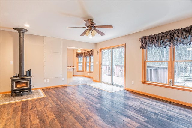26 Cowboy Trl, Saugerties, NY 12477 - unfurnished living room featuring a wood stove, a ceiling fan, visible vents, wood finished floors, and baseboards