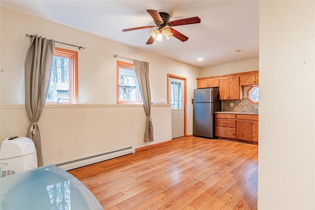 26 Cowboy Trl, Saugerties, NY 12477 - kitchen with a wealth of natural light, brown cabinets, a baseboard radiator, and freestanding refrigerator
