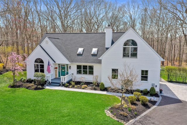 view of front of property with a front yard, a shingled roof, a chimney, and fence