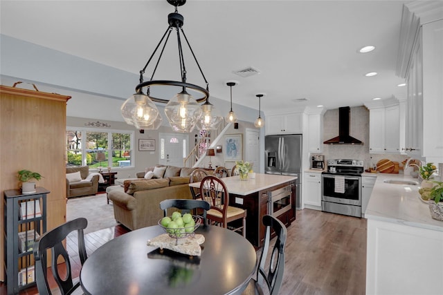 dining space featuring wood finished floors, visible vents, and recessed lighting