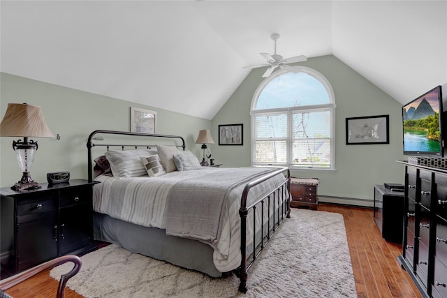 bedroom with a baseboard radiator, vaulted ceiling, ceiling fan, and light wood-style flooring