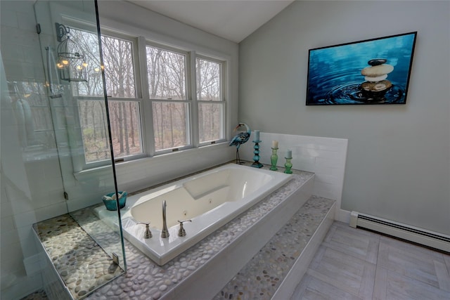 bathroom with a tub with jets, vaulted ceiling, a healthy amount of sunlight, and a tile shower