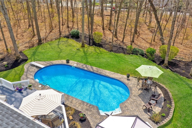 outdoor pool with a yard, a patio area, fence, and a deck