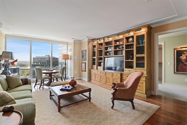 living room featuring baseboards, expansive windows, light wood finished floors, and crown molding