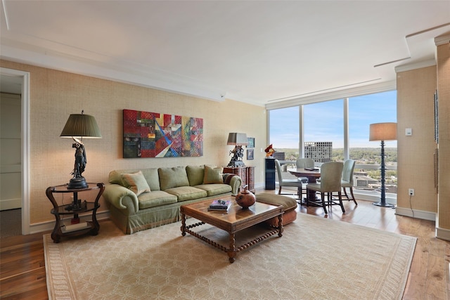 living area featuring baseboards, crown molding, expansive windows, and hardwood / wood-style flooring