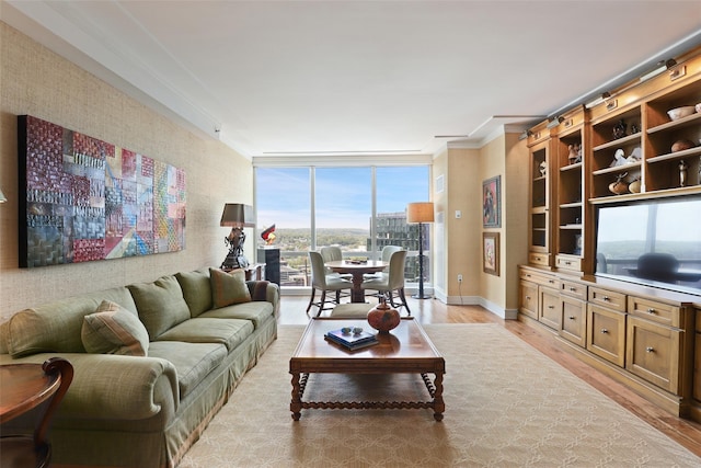 living room with expansive windows, light wood-style flooring, crown molding, and baseboards