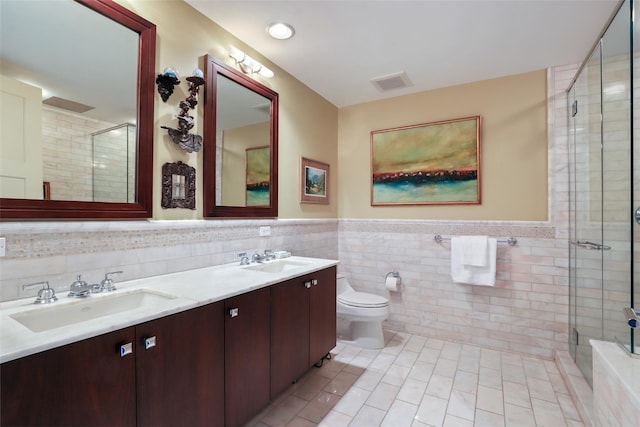 bathroom featuring tiled shower, tile patterned floors, visible vents, and a sink