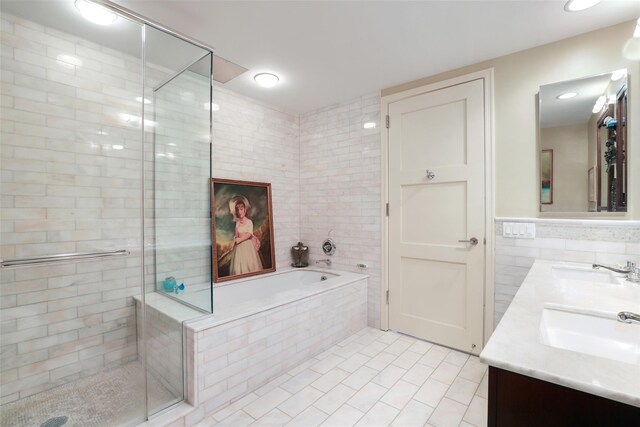 full bathroom with a sink, tile walls, a bath, tile patterned flooring, and a shower stall