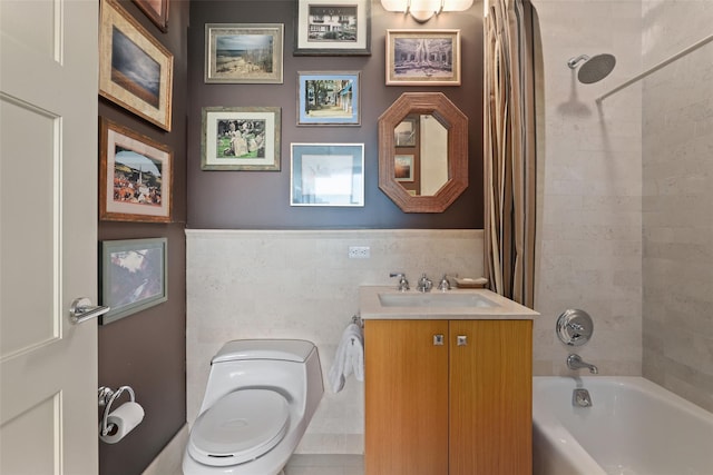 bathroom featuring tile walls, toilet, shower / tub combo with curtain, vanity, and a wainscoted wall