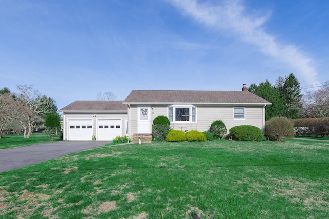 ranch-style home featuring a chimney, an attached garage, driveway, roof with shingles, and a front yard