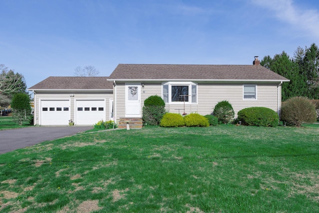 ranch-style home with a chimney, a front lawn, aphalt driveway, a garage, and roof with shingles