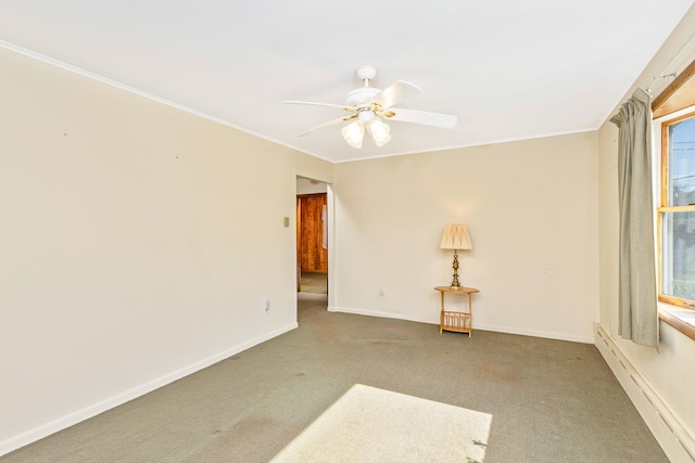 carpeted spare room featuring ornamental molding, baseboards, and ceiling fan