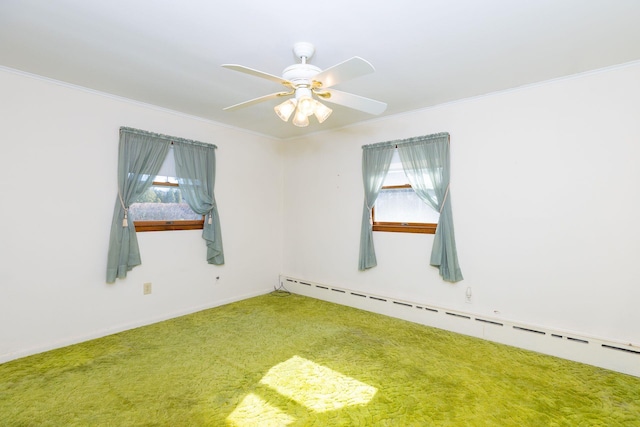 carpeted spare room featuring plenty of natural light, crown molding, and baseboard heating
