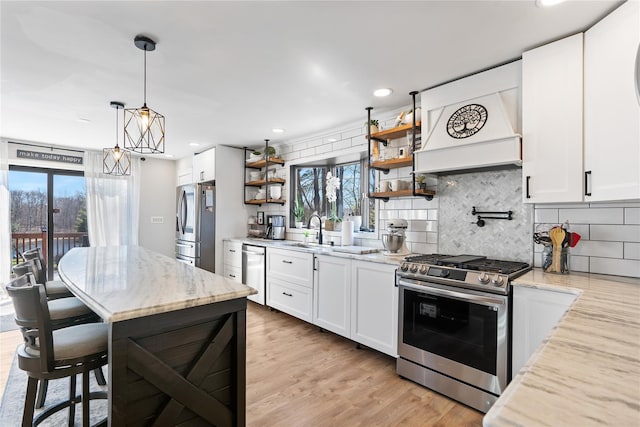 kitchen with light stone counters, open shelves, decorative backsplash, appliances with stainless steel finishes, and custom range hood