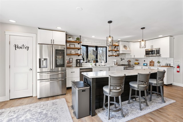 kitchen with open shelves, backsplash, a sink, appliances with stainless steel finishes, and white cabinetry