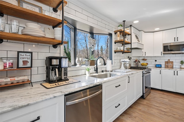 kitchen with open shelves, decorative backsplash, a sink, and appliances with stainless steel finishes