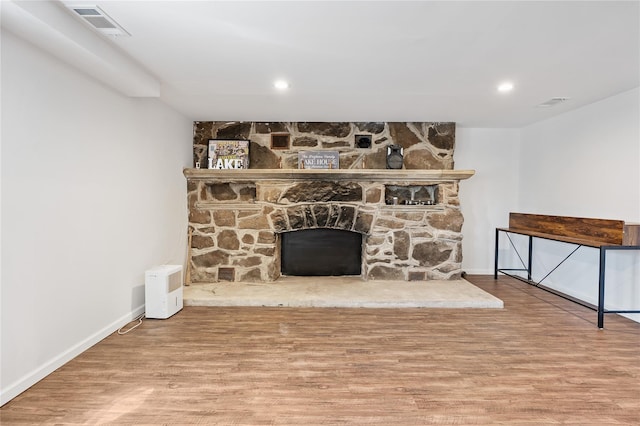 unfurnished living room featuring visible vents, baseboards, wood finished floors, and a fireplace
