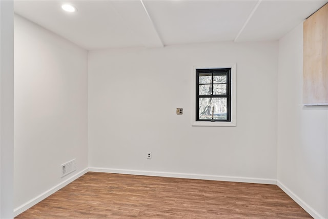 empty room with visible vents, baseboards, wood finished floors, and recessed lighting