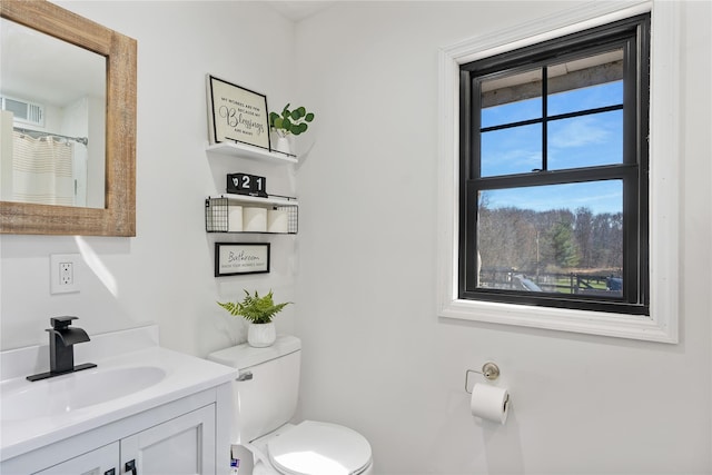 full bath featuring toilet, vanity, and visible vents