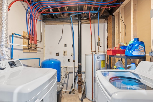 washroom with washing machine and dryer, water heater, and laundry area