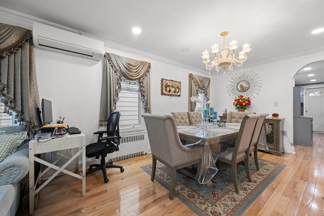 dining space with a wall mounted AC, arched walkways, a chandelier, and light wood finished floors