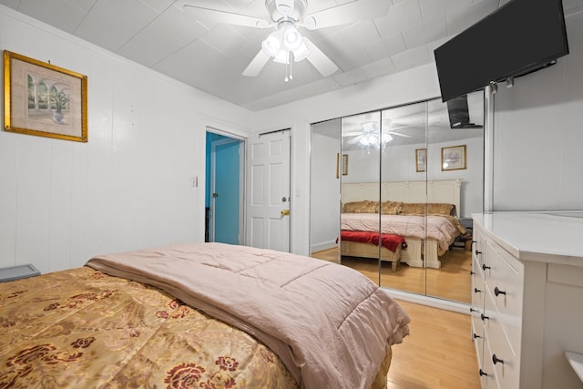 bedroom featuring a closet, light wood finished floors, and ceiling fan