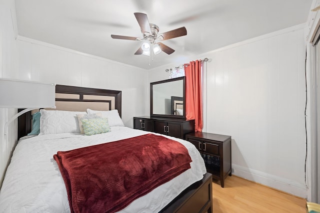bedroom with light wood-style floors, baseboards, ornamental molding, and a ceiling fan