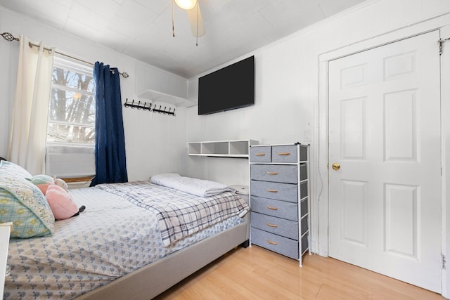bedroom with ceiling fan, crown molding, and wood finished floors