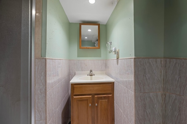 bathroom featuring tile walls, vanity, and wainscoting