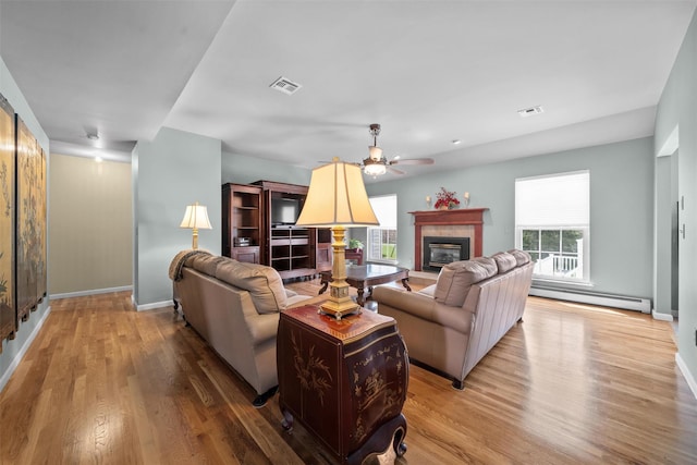 7 Center Cir, Florida, NY 10921 - living area with light wood finished floors, a ceiling fan, a baseboard heating unit, baseboards, and a tiled fireplace
