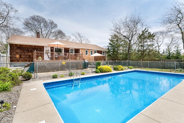 view of swimming pool with a deck, fence, and a fenced in pool