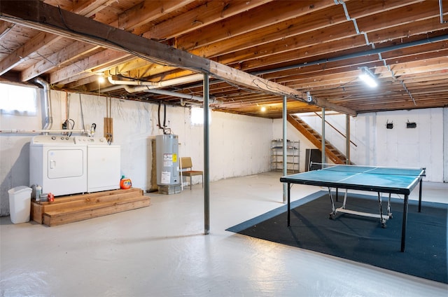 below grade area featuring stairway, water heater, and independent washer and dryer