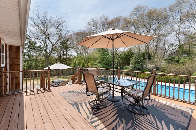 deck featuring fence, outdoor dining area, and a fenced in pool