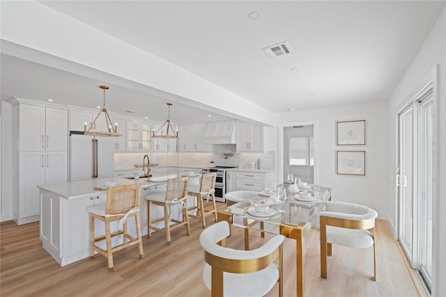 dining area with a healthy amount of sunlight, visible vents, and light wood-style flooring