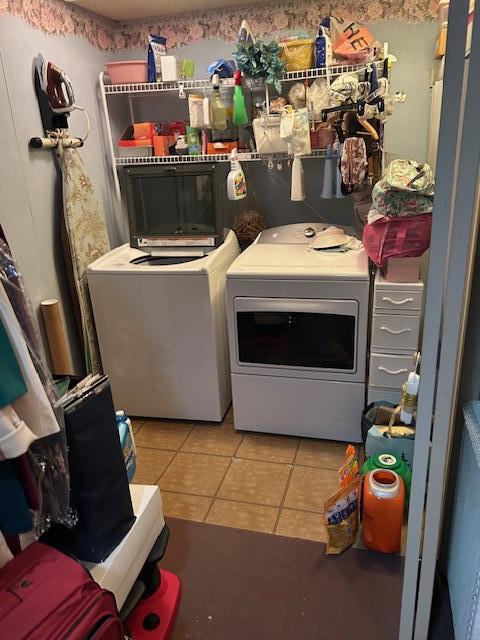 washroom featuring laundry area, independent washer and dryer, and light tile patterned flooring