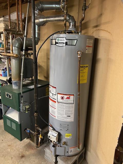 utility room with a heating unit and gas water heater