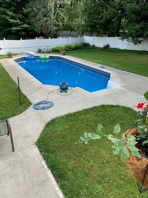 view of swimming pool with a fenced in pool, a fenced backyard, a lawn, and a patio area