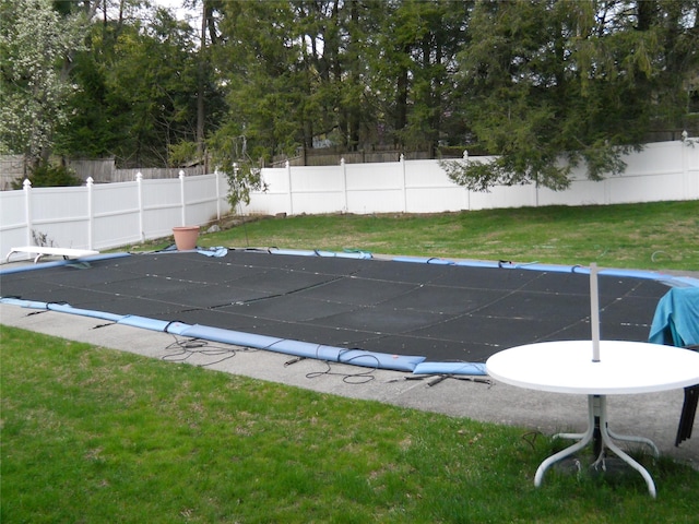 view of pool featuring a fenced in pool, a lawn, and fence