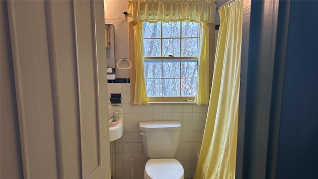 full bath with tile walls and toilet