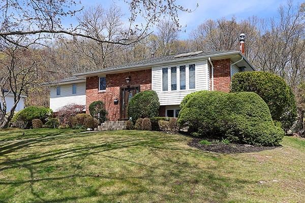 80 Lauren Ave, Dix Hills, NY 11746 - split foyer home with brick siding, a chimney, and a front lawn