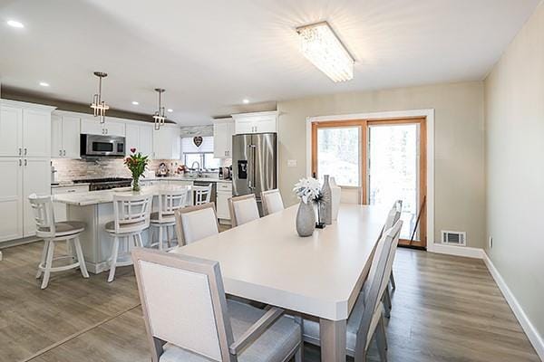 80 Lauren Ave, Dix Hills, NY 11746 - dining space with healthy amount of natural light, recessed lighting, wood finished floors, and baseboards