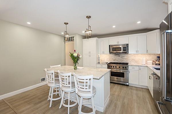 80 Lauren Ave, Dix Hills, NY 11746 - kitchen with premium appliances, light wood finished floors, backsplash, white cabinetry, and recessed lighting