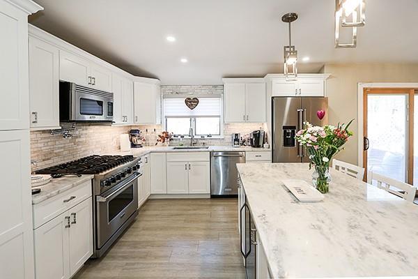 80 Lauren Ave, Dix Hills, NY 11746 - kitchen featuring premium appliances, a sink, white cabinetry, recessed lighting, and backsplash