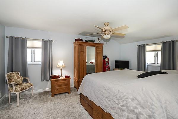 80 Lauren Ave, Dix Hills, NY 11746 - bedroom with multiple windows, light colored carpet, and baseboards