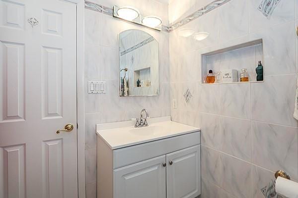 80 Lauren Ave, Dix Hills, NY 11746 - bathroom with vanity and tile walls
